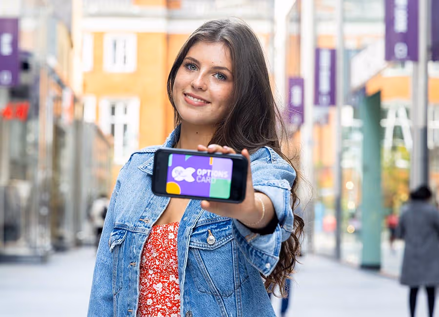 Sarah-Jane holding her phone with an OptionsCard on the high street